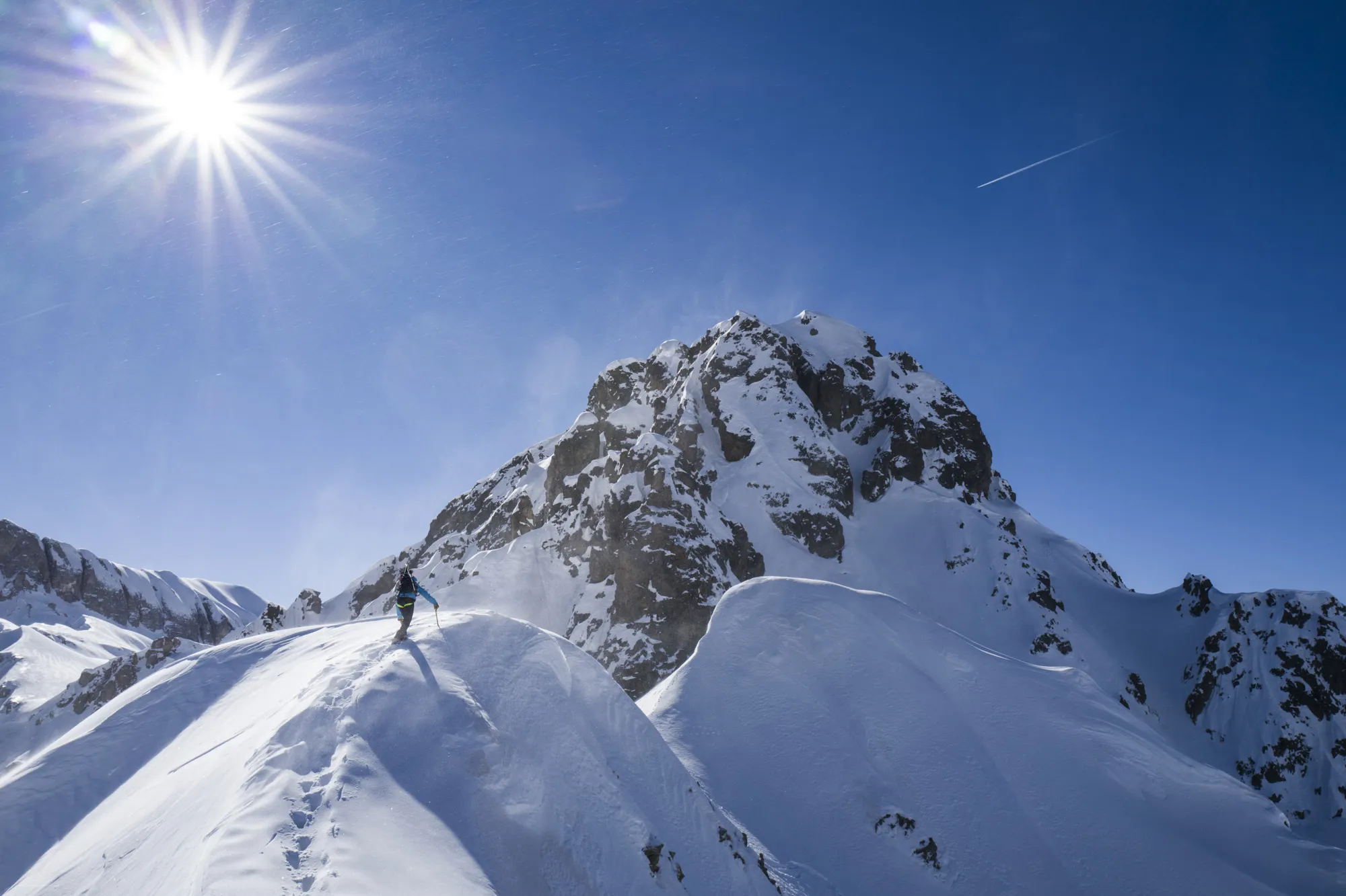 Un alpiniste gravit le sommet d'une cime avec les guides du Beaufortain